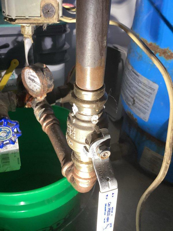 Technician responded to customer-reported leak near well pump system. Upon inspection, identified leak at the tank tee connection by pressure tank. Evaluated system components including copper piping, brass valves, and pressure gauge assembly. Provided estimate for tank tee replacement to resolve the active leak.