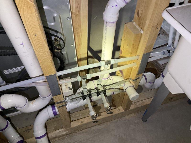 Completed comprehensive plumbing installation for bathroom renovation including installation of Sterling shower unit with mortar-set base, new drain assembly, and customer-supplied fixtures. Executed kitchen and laundry room plumbing modifications with installation of new PVC drain piping, vent piping, and PEX water supply lines for multiple fixtures. Installed and connected all customer-supplied bathroom fixtures including toilet, sink faucet, and shower trim with appropriate supply lines and drainage components.