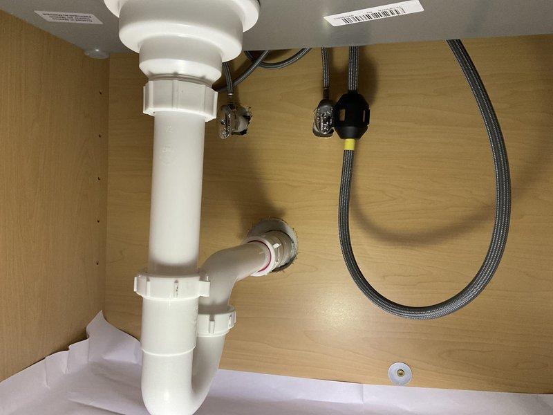 Completed comprehensive plumbing installation for bathroom renovation including installation of Sterling shower unit with mortar-set base, new drain assembly, and customer-supplied fixtures. Executed kitchen and laundry room plumbing modifications with installation of new PVC drain piping, vent piping, and PEX water supply lines for multiple fixtures. Installed and connected all customer-supplied bathroom fixtures including toilet, sink faucet, and shower trim with appropriate supply lines and drainage components.