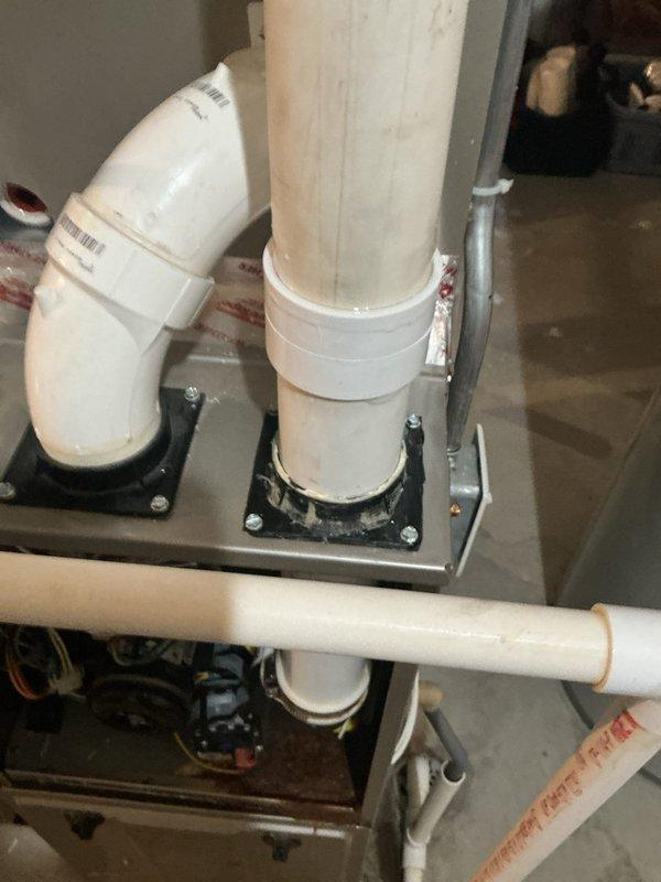 Replaced defective rubber coupling on furnace PVC vent pipe that was causing water leakage. Installed new PVC coupler to properly connect the previously broken PVC sections, eliminating condensation buildup and resolving the drainage issue.