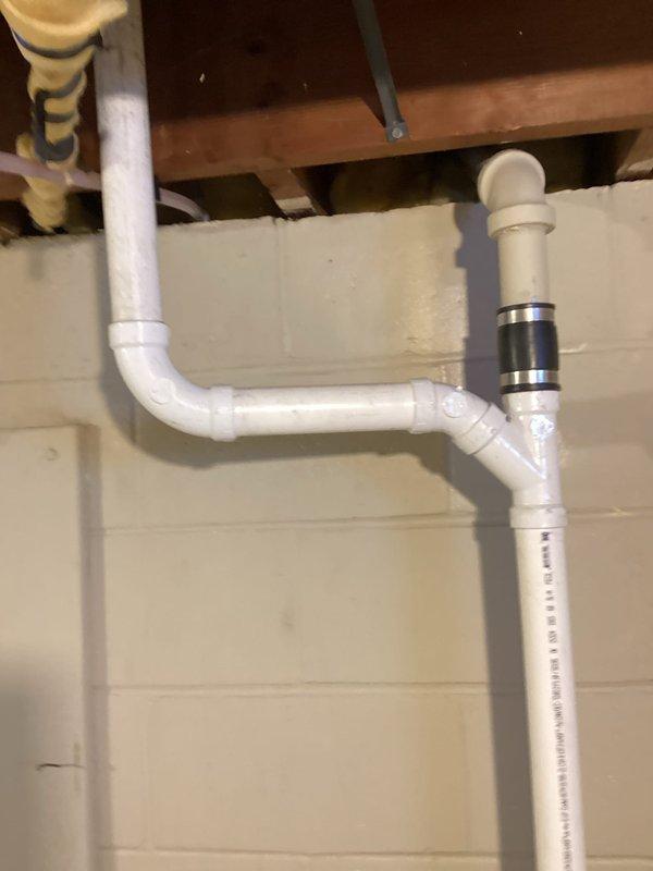 Responded to call for kitchen sink leak causing basement damage. Upon inspection, found rotted sink arm requiring replacement. Completed repiping of kitchen sink drain system, installing new PVC drain assembly with proper P-trap and vertical waste line that connects to the main drainage system. Verified proper operation with no leaks.