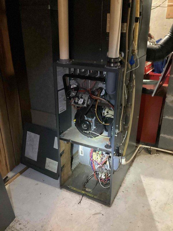 Responded to no-heat call on 20+ year old Amana/Goodman furnace. Diagnosed multiple issues including faulty door safety switch, temporarily jumpered for testing. Found pressure switch error caused by compromised hose which was replaced, resolving ignition failure. Noted inducer motor operating loudly though functionally. Inspected heat exchanger with no compromised areas found. Advised customer that return visit needed to properly replace door switch and recommended evaluation of pressure switch and inducer motor. Due to age and condition of unit, scheduled comprehensive system evaluation to discuss replacement options.