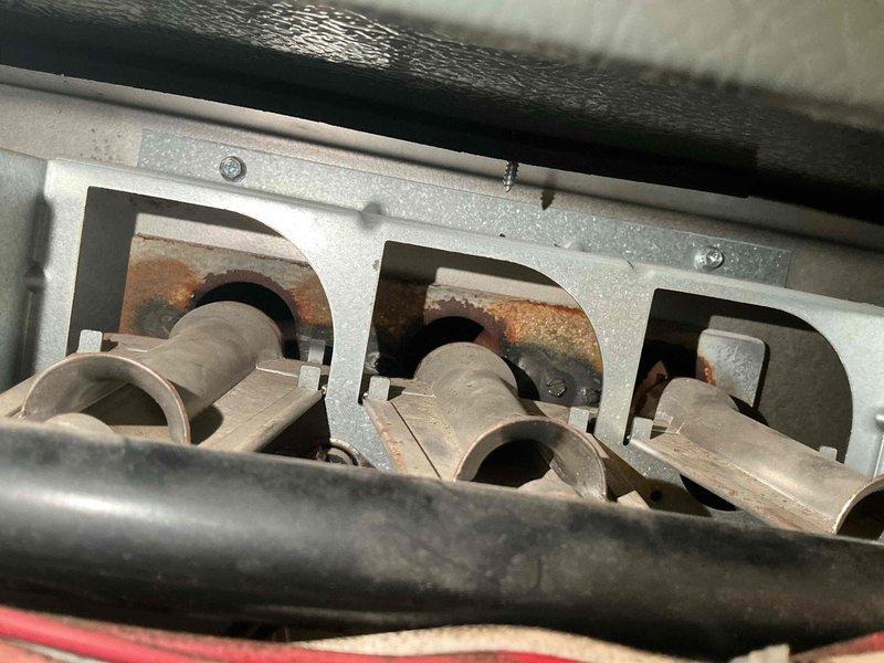 Responded to no heat complaint in residence. Diagnosed tripped flame rollout switch and inspected heat exchanger, revealing severe rust and burn damage at flame entry points. Observed improper flame pattern with rollout at burner sides and orange flames within tubes. Due to extensive heat exchanger deterioration and safety concerns, determined unit was unsafe for operation. Replacement of 14-year-old furnace recommended and scheduled.