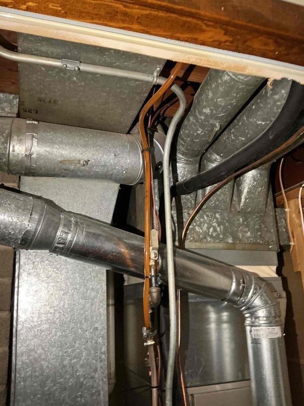 Performed standard furnace tune-up on residential FRP unit of unknown age. System inspection revealed normal operation with no immediate concerns. Conducted comprehensive maintenance including combustion analysis, gas pressure verification, inspection of heat exchanger, flame sensor, burners, and blower components. Confirmed proper thermostat operation and heating performance. Air filter in good condition; cleaned pressure switch. Documented system with photos showing ductwork configuration and motor assembly.