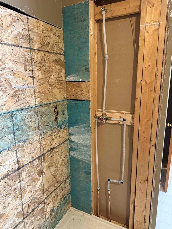 Completed shower remodel including installation of new shower drain and diverter. Repiped both the drain system and water supply lines using PVC with proper primer at joints and secured new plumbing to wall framing with mounting brackets. No inspection or permits were required for this installation.