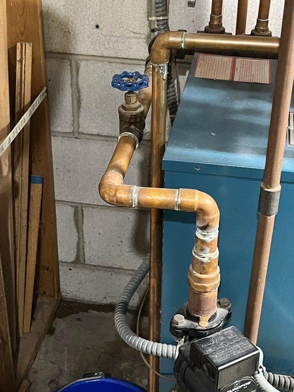 Responded to service call for a leaking shut-off valve on a 10+ year old boiler system. Inspection revealed significant corrosion and mineral deposits on a 1-inch copper pipe valve that had begun leaking. Performed complete valve replacement, including system drainage and proper refill to restore proper operation.