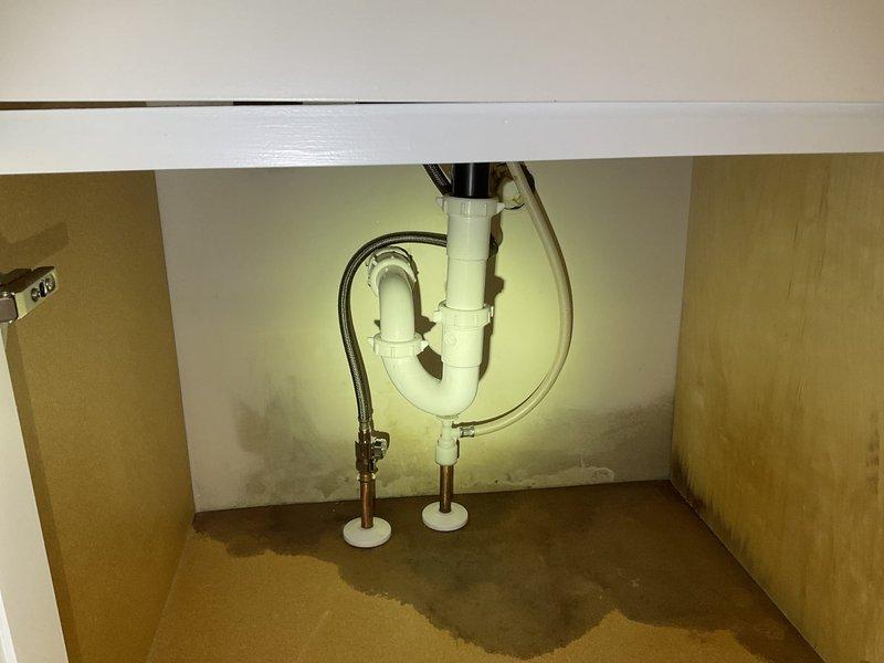 Responded to a water leak service call for master bathroom sink. Identified leaking plastic angle stops and supply tube on left side of vanity with visible water damage to cabinet base. Replaced faulty stops and supply tubes in master bathroom, main bathroom, and powder bathroom to prevent further damage.