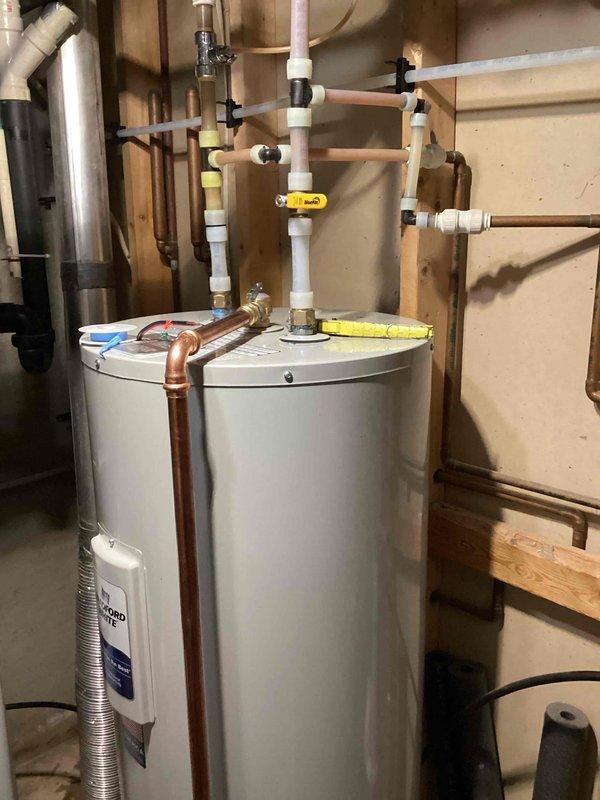 Responded to service call regarding water heater leakage and burning odor. Assessed existing unit which showed signs of significant failure. Replaced damaged water heater with new equipment, completing all necessary plumbing connections including proper PVC ventilation and copper supply lines with appropriate valving. Installation verified with no leaks upon completion.