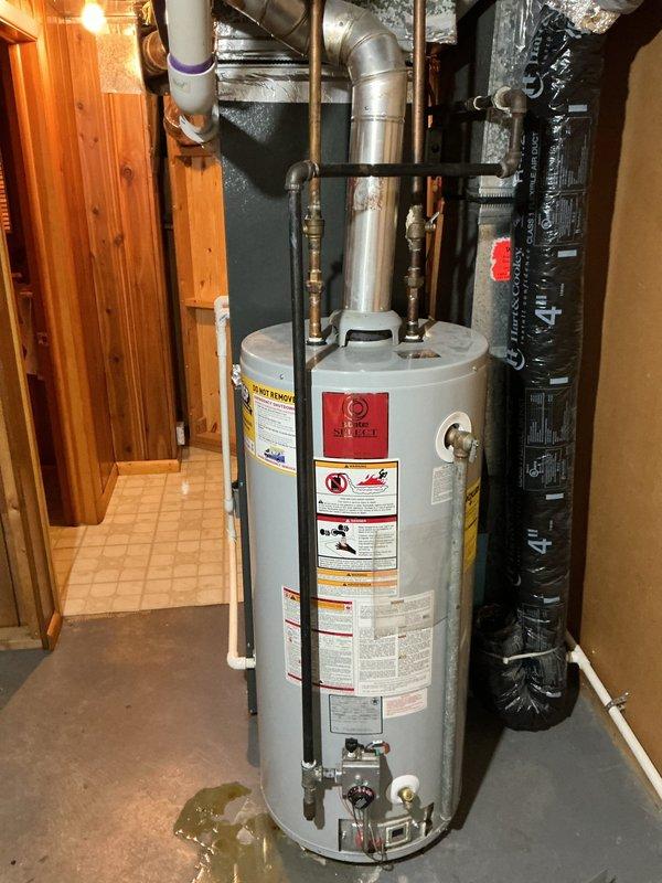 Responded to service call for water heater leakage in basement utility area. Diagnostic inspection revealed pooling water at base of unit. Replaced failed water heater tank with new unit, ensuring proper connections to existing copper and PVC supply lines and exhaust venting. System tested for proper operation and leaks before concluding service.