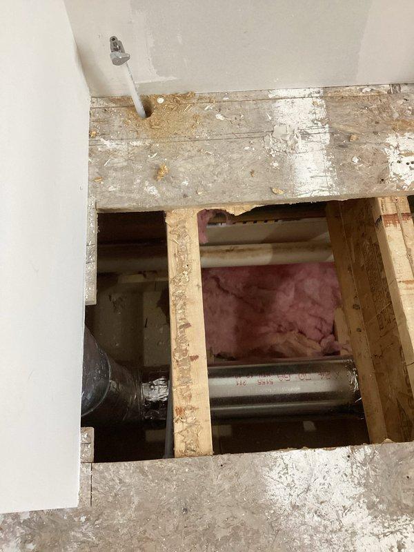 Successfully ran a new water supply line for refrigerator, requiring access through floor/ceiling space. Installed proper connections and verified functionality of the water line, with photographic documentation of the installation area showing exposed structural elements and the newly installed supply line.