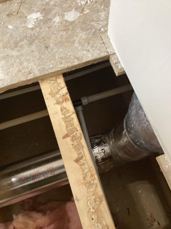 Successfully ran a new water supply line for refrigerator, requiring access through floor/ceiling space. Installed proper connections and verified functionality of the water line, with photographic documentation of the installation area showing exposed structural elements and the newly installed supply line.