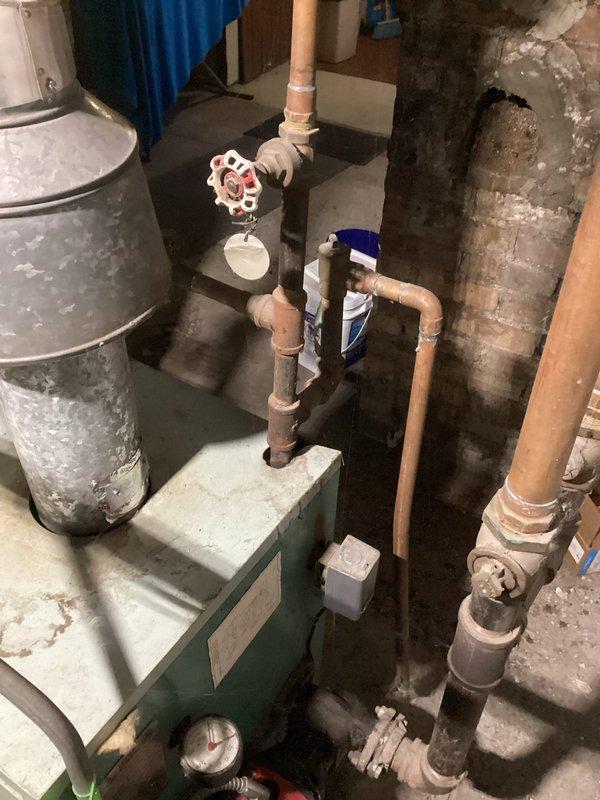 Responded to service call for radiator heating issue on upper floor. Diagnosed air in radiators and low boiler pressure (10 psi). Identified seized backflow preventer that was leaking when attempting to add water. Also discovered non-code compliant gas shutoff valve with active leak causing gas odor near boiler. Successfully filled system with water, bled radiators, and restored pressure to 19 psi, resolving heating complaint. Recommended replacement of backflow preventer and gas shutoff valve.