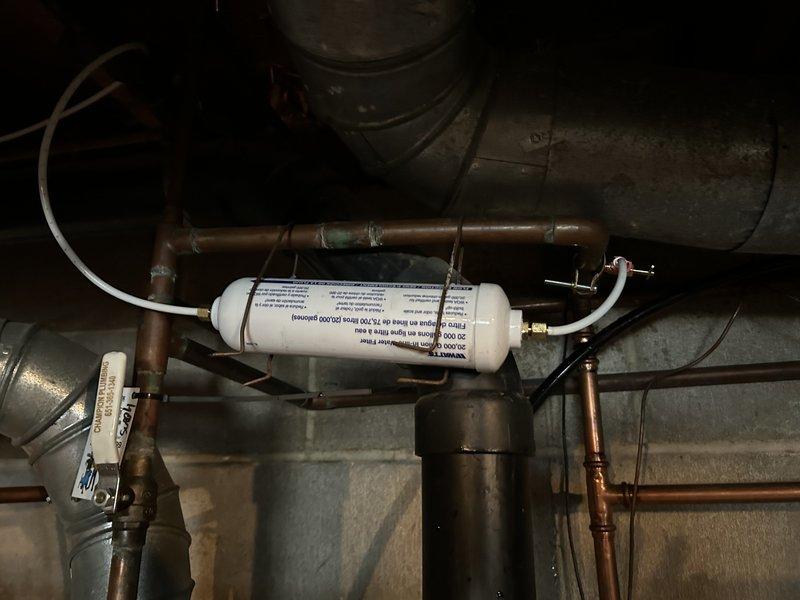 Responded to service call for water line connection to Whirlpool refrigerator. Upon inspection, determined water supply system was functioning properly with adequate line pressure at the filter assembly, but no water was dispensing from the refrigerator outlet. Diagnosed issue as internal refrigerator malfunction rather than plumbing problem. Advised customer to contact Whirlpool manufacturer for warranty service.