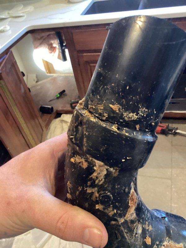 Completed kitchen drain rerouting project which involved cutting a 2" drain in basement, removing sheetrock behind lazy susan cabinet, and installing new kitchen drain line through cabinet floor. Successfully tied vent into basement drain and installed an Air Admittance Valve (AAV) for proper venting. Connected kitchen sink drains as needed to complete the plumbing system.