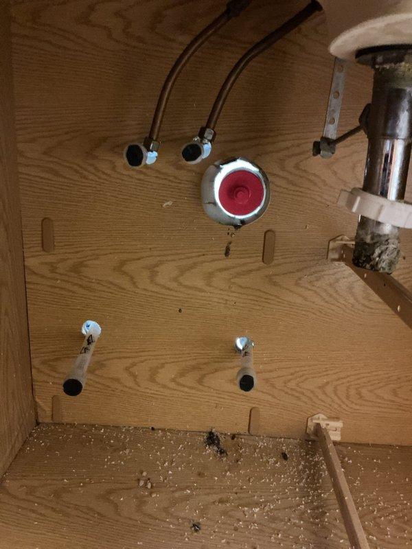 Disconnected bathroom vanity plumbing per customer request to facilitate contractor renovation. Capped water supply lines and PVC drain pipes after removing faucet fixtures. Left all connection points properly sealed and secured for future reinstallation.