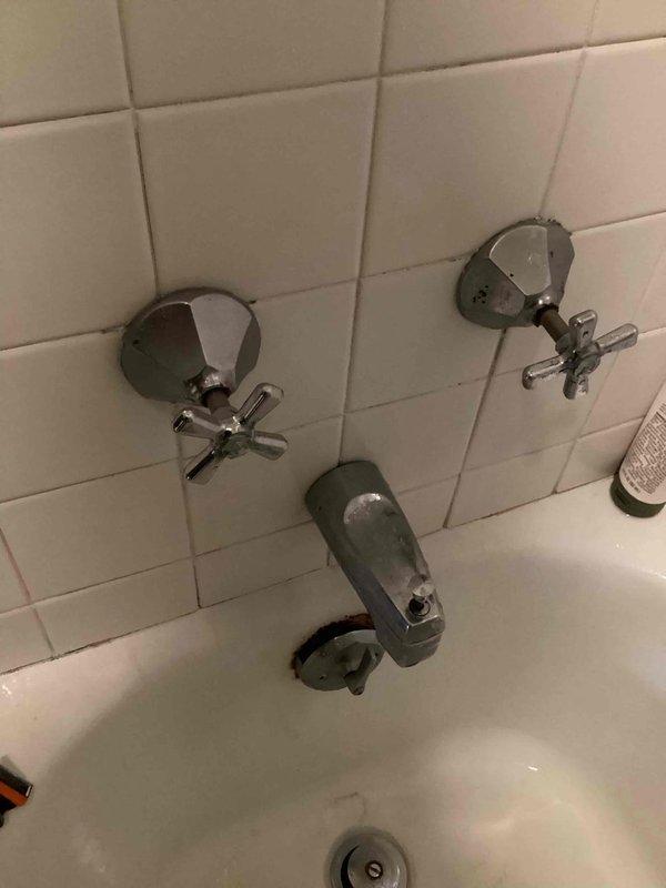 Investigated and repaired water leakage from bathtub/shower area that was penetrating through ceiling into basement below. Identified two sources of water intrusion: defective overflow assembly and deteriorated seal around left shower handle. Presented customer with multiple remediation options and completed necessary repairs to prevent further water damage to structural components.