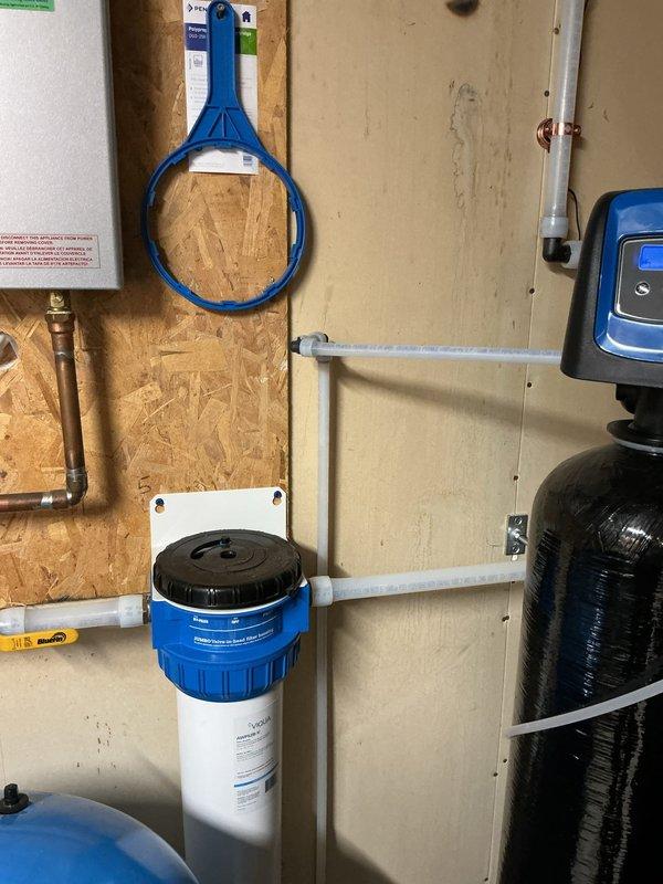 Re-piped customer's water lines to ensure all water from the well passes through the sediment filtration system as originally intended. This included rerouting the kitchen and exterior faucet supply lines through the existing filter, correcting the bypass issue that was previously allowing unfiltered water to these fixtures. Installation now configured properly with all domestic water properly filtered per customer request.