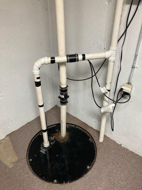 Inspected homeowner's sump pump system that had been previously repaired with hose clamps and electrical tape. Identified leaking check valve in sewer ejector system. Reviewed proper installation requirements with customer who elected to perform the replacement themselves.