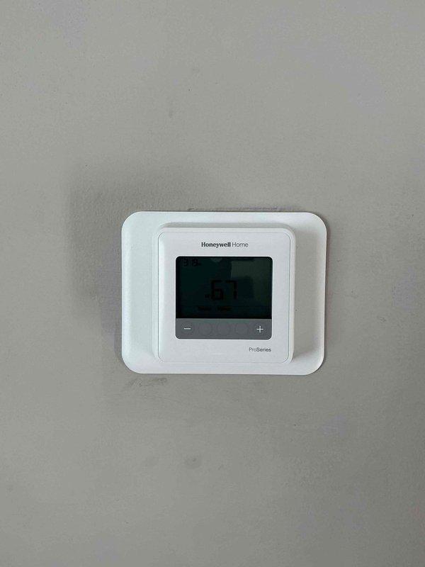 Diagnosed thermostat malfunction causing no heat condition. Replaced faulty thermostat with new Honeywell Home ProSeries unit, cleaned burners to restore proper combustion, and replenished low water level in boiler system to restore proper operation.