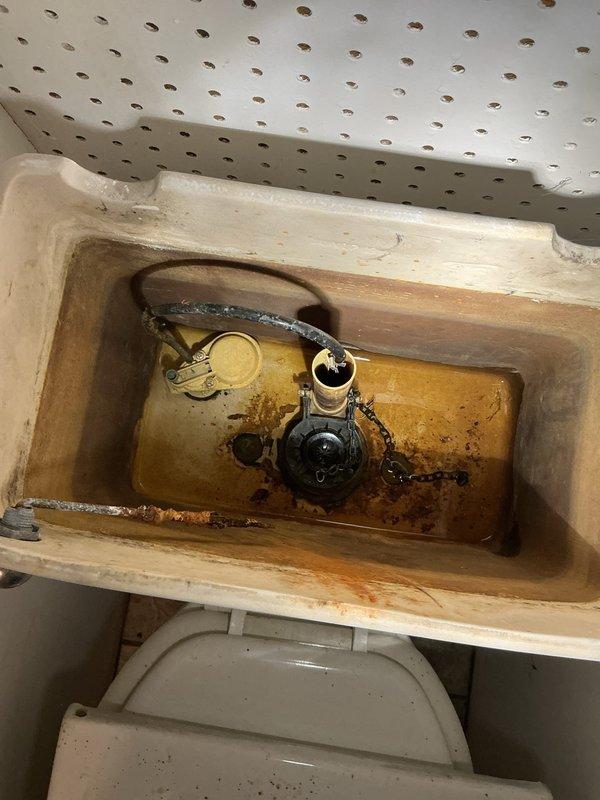 Inspected deteriorated toilet mechanism exhibiting significant mineral deposits and staining. Diagnosed faulty handle and flapper causing toilet malfunction. Successfully installed new toilet handle and flapper assembly, restoring proper flushing functionality.