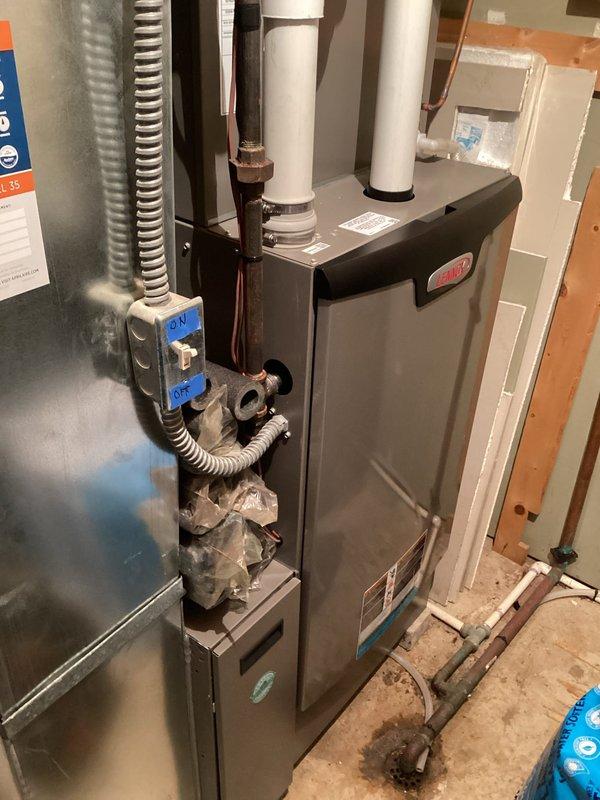 Responded to customer report of a leaking humidifier after homeowner-attempted water panel replacement. Diagnosed issue at the humidifier solenoid hose connection, disassembled fitting, cleaned components, and reinstalled properly. Monitored system for 15 minutes to confirm successful leak resolution on the Aprilaire humidifier unit mounted to the Lennox furnace system.