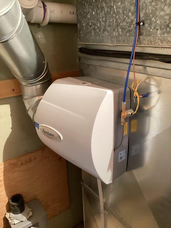 Responded to customer report of a leaking humidifier after homeowner-attempted water panel replacement. Diagnosed issue at the humidifier solenoid hose connection, disassembled fitting, cleaned components, and reinstalled properly. Monitored system for 15 minutes to confirm successful leak resolution on the Aprilaire humidifier unit mounted to the Lennox furnace system.