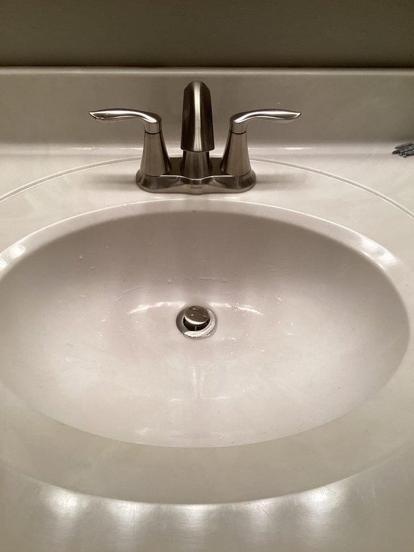 Responded to leak in basement bathroom sink. Diagnosed faulty faucet causing water to leak from underneath fixture. Removed and replaced bathroom faucet assembly with new unit, resolving the leak issue. Also inspected tanked water heater and provided recommendation for maintenance service.