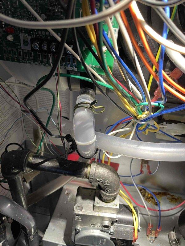 Responded to furnace short cycling complaint. Found inducer filled with water due to improper coupling angle causing air lock before drainage. Repositioned inducer coupling downward and adjusted vinyl tubing connection to improve drainage. Additionally diagnosed erratic thermostat behavior at setpoint; replaced thermostat which resolved irregular cycling issues. System now properly maintaining temperature and shutting off appropriately at setpoint.