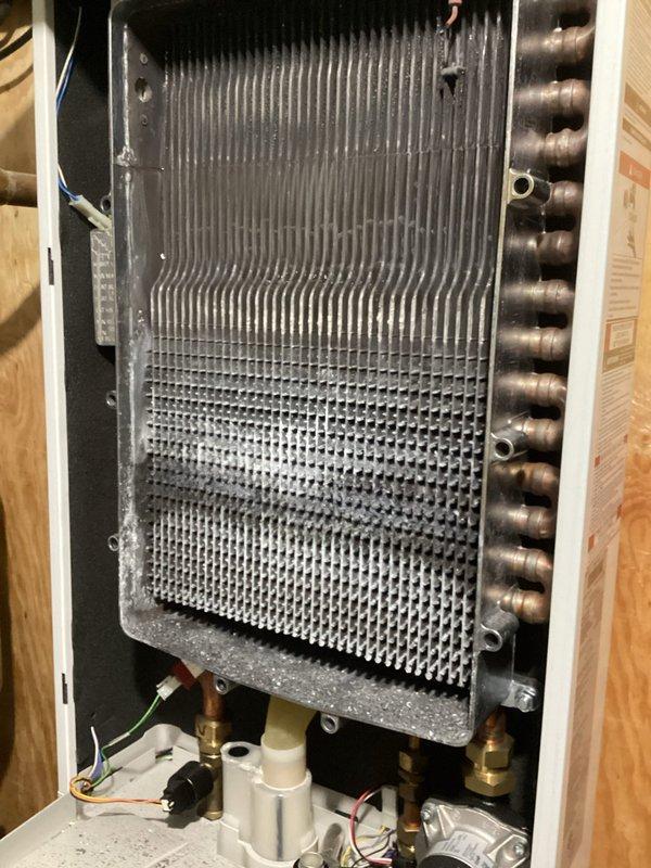 Responded to no heat/no hot water service call for a 2020 boiler. Diagnosed plugged condensate trap causing water backup. Performed comprehensive tuneup including thorough cleaning of heavily soiled heat exchanger with significant dust accumulation on fins, restored proper system operation, and enrolled customer in rewards program.
