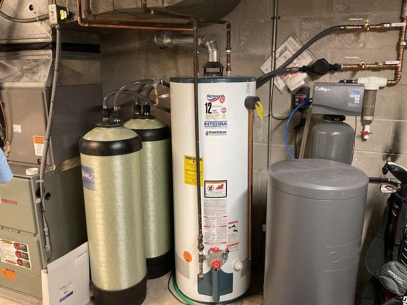 Responded to customer complaint of onion-like odor from hot water supply. Examined 17-year-old Richmond water heater (model 12S50-40F1, manufactured 07/2006) which was functioning properly despite age. Attempted to remove anode rod to address sulfur smell issue but found it seized. Advised customer against further removal attempts due to risk of tank damage on aged unit and recommended complete water heater replacement as most appropriate solution.