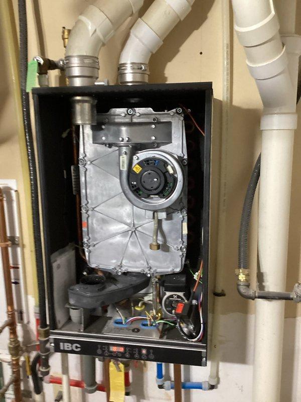 Performed scheduled maintenance on IBC combi boiler as part of recurring service agreement. Found heavily plugged heat exchanger which required extensive cleaning; also flushed condensate, cleaned flame sensor, and restored system pressure to proper level from 8 psi. All operations verified normal after service completion.