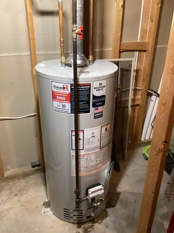 Replaced non-functioning 40-gallon natural gas storage vessel water heater in basement utility room. New Bradford White unit was installed with proper connections to existing copper supply lines, gas line, and metal flue pipe. Customer reported no hot water prior to service; system is now operational.