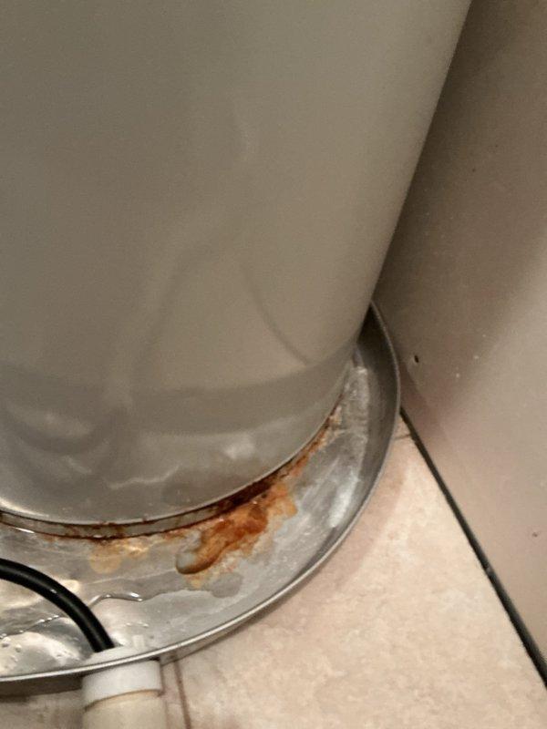Diagnosed 20-year-old A.O. Smith 50-gallon electric water heater with active leak from tank bottom, evidenced by significant rust formation at base. Determined unit had reached end of serviceable life due to tank failure. Removed failed unit and installed new water heater with proper connections to existing plumbing system.
