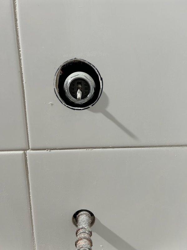 Inspected shower valve system where ball valve does not extend beyond tile surface. Identified need for replacement with a splitter valve. Examined existing tub/shower installation with recessed drain cover and spout. Provided estimate for bathroom completion work.
