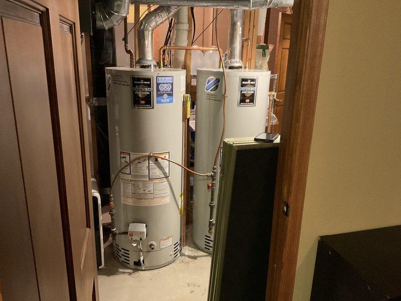 Performed inspection of two 2017 Bradford White 50-gallon natural gas water heaters to investigate reported condensation at base of units. Customer had previously observed moisture around one heater, but no active leakage or condensation was detected during inspection. Both units appear to be functioning normally at present. Provided customer with replacement options including dual 50-gallon heater installation or upgrade to single 75-gallon unit.