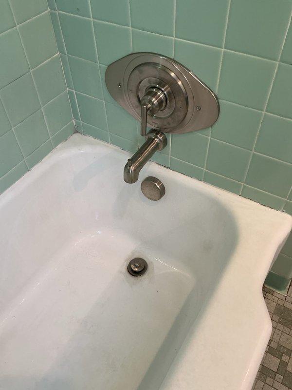 Completed installation of customer-supplied tub shower valve, spout, and shower head in bathroom with mint green tile surround. Work was performed as per previous estimate, utilizing existing access from behind the valve. No warranty provided for customer-supplied materials as per company policy.