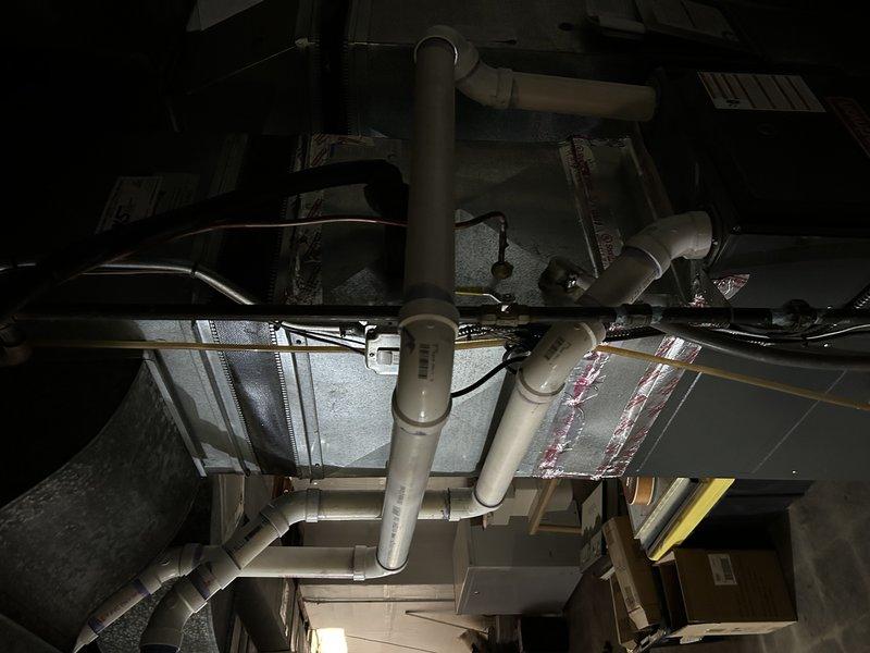 Responded to warranty service call for 2021 furnace installation. Diagnosed PVC condensate line leak occurring at two 90-degree elbow joints. Removed damaged section and replaced with new PVC piping, applying appropriate primer and adhesive at connection points to ensure proper sealing and prevent future leakage.