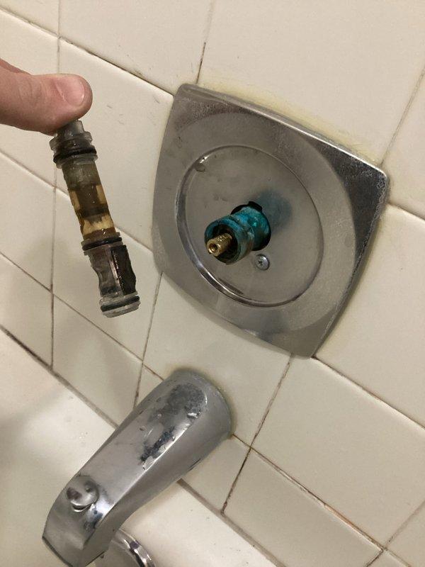 Responded to service call for leaky tub faucet. Upon inspection, found deteriorated shower valve cartridge with significant mineral buildup. Removed old Moen cartridge and replaced with customer-supplied replacement part. Successfully restored proper function and eliminated leak.