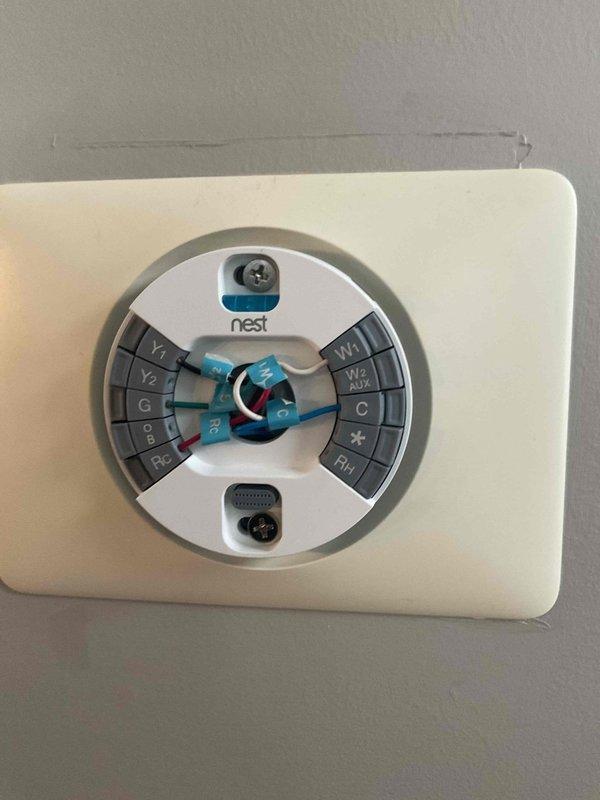 Performed annual furnace tune-up on FRP unit of undetermined age. Cleaned clogged condensate drain and trap to restore proper drainage. Documented system components with photos, including the Nest thermostat configuration and mounting hardware.