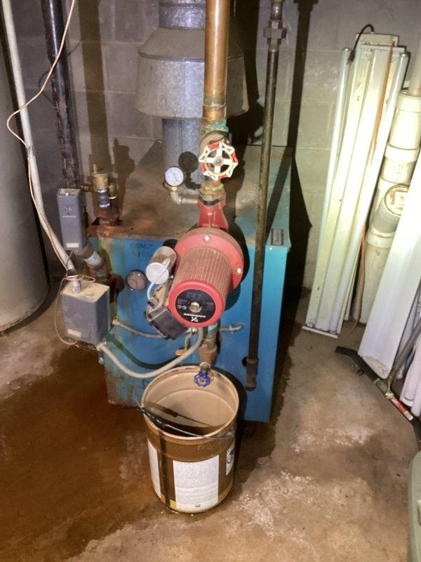 Responded to emergency service call for 18-unit apartment building with no heat. Found boiler actively leaking from cast plates with extensive water damage to surrounding ceiling and structure. Inspection revealed burned wiring inside the unit and catastrophic failure of the system. Documented damage with photos and arranged for service advisor to provide quote for complete boiler replacement due to irreparable condition.