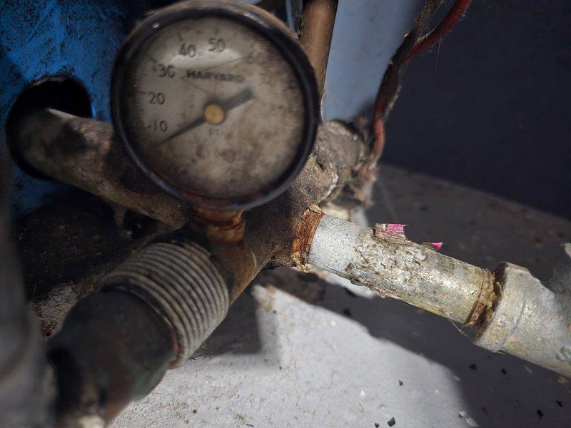 Diagnosed water pressure system failure with pressure tank operating at critically low 1-5 PSI causing no water pressure in home. Installed new pressure switch to restore system functionality after confirming severe corrosion at pipe junctions and pressure gauge connections. System now operating within normal parameters.