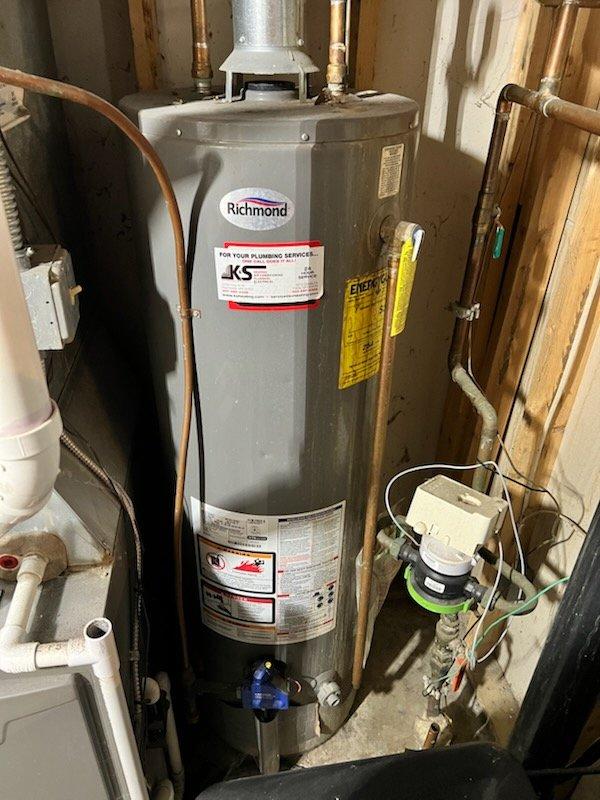 Responded to service call for non-functioning water heater. Upon inspection, determined existing Richmond tank-style water heater had failed due to age. Removed old unit and installed new replacement water heater, connecting all necessary copper and PVC piping. System now operating properly with hot water restored.