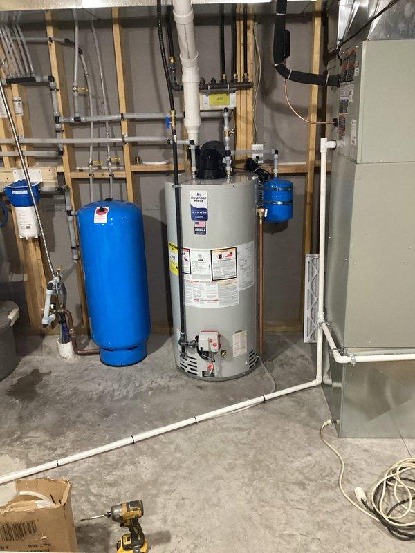 Responded to warranty call regarding lukewarm hot water. Determined water heater was sooted due to low gas pressure. Replaced water heater and coordinated with River Valley to replace regulator and verify proper gas pressures. Documented electrical panel and utility room configuration with photos.