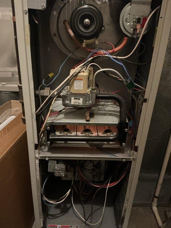 Diagnosed 29-year-old furnace with multiple critical failures including cracked heat exchanger causing carbon monoxide leakage, oil-leaking blower motor, burn marks on control board resistors, and limit switch activation due to overheating. Due to safety concerns and extensive component failures, recommended full system replacement and scheduled estimate appointment for new furnace installation.