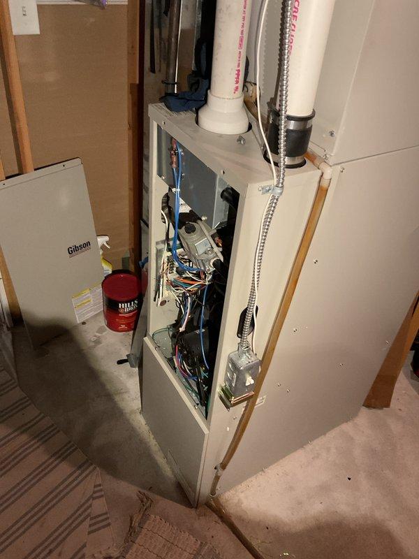 Responded to no heat call for 15-year-old Gibson furnace unable to maintain temperatures above 65°F. Diagnostic revealed slow blinking yellow indicator light and plugged condensate trap. Performed maintenance by cleaning flame sensor with Scotch-Brite pad and clearing blocked drain line, which restored proper operation. Monitored system until temperature reached 67°F, confirming successful repair.