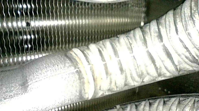 Diagnosed no heat issue in aging system, finding extensive rust damage in the inducer motor assembly and heat exchanger. Visual inspection revealed significant corrosion in the ductwork and deterioration of the heat exchanger fins. Recommended system replacement due to equipment age, extent of rust damage, and prohibitive repair costs compared to replacement value.