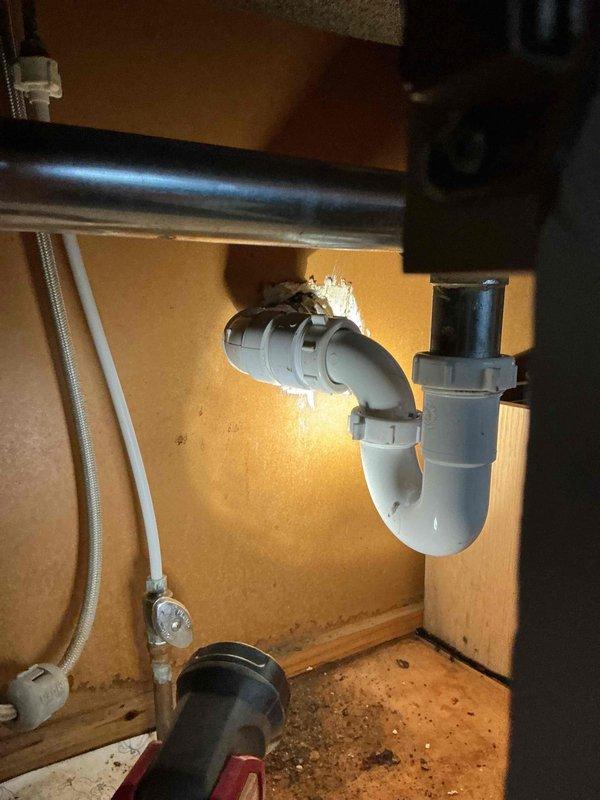 Responded to kitchen sink leak caused by a hole in galvanized nipple. Replaced deteriorated galvanized pipe fitting with new PVC components and installed proper P-trap assembly to ensure proper drainage and eliminate leak.