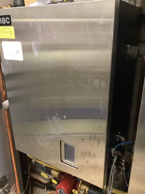 Responded to service call for IBC SL boiler system with high temperature lockout. Diagnosed air-locked circulator pump on secondary boiler (199K BTU). Bled air from pump, reset controller, and verified normal operation of both boilers and all circulation pumps in the heating system.