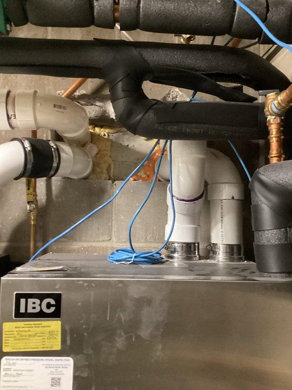Responded to service call for IBC SL boiler system with high temperature lockout. Diagnosed air-locked circulator pump on secondary boiler (199K BTU). Bled air from pump, reset controller, and verified normal operation of both boilers and all circulation pumps in the heating system.