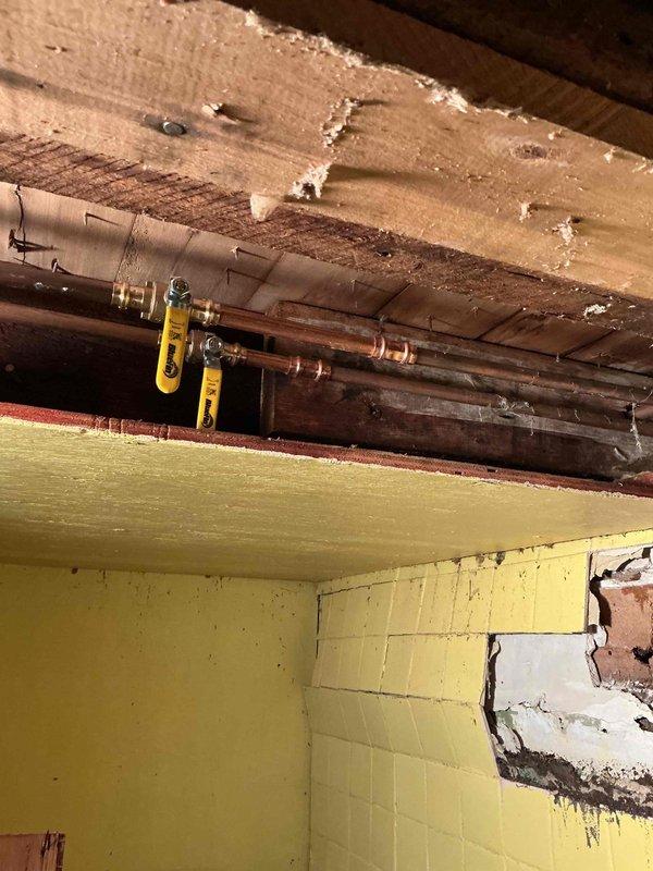 Responded to emergency call for a burst half-inch copper line in unfinished basement that required homeowner to shut off whole house water supply. Repaired split copper waterline and installed isolation valves for bathroom at far end of house, providing sectional water shut-off capability to prevent future whole-house water interruptions during repairs.